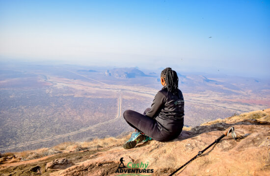 Adventurer and team leader celebrating triumph at the summit of Mt. Ololokwe, Samburu County, Kenya