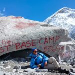 Jane Gatonye standing triumphantly at the base camp of Mt. Everest, surrounded by the breathtaking Himalayan landscape