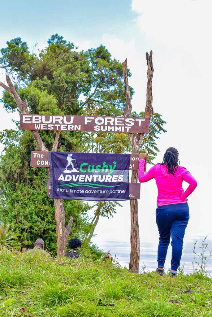 Cushy Community hiker at Eburru Western Summit sign.