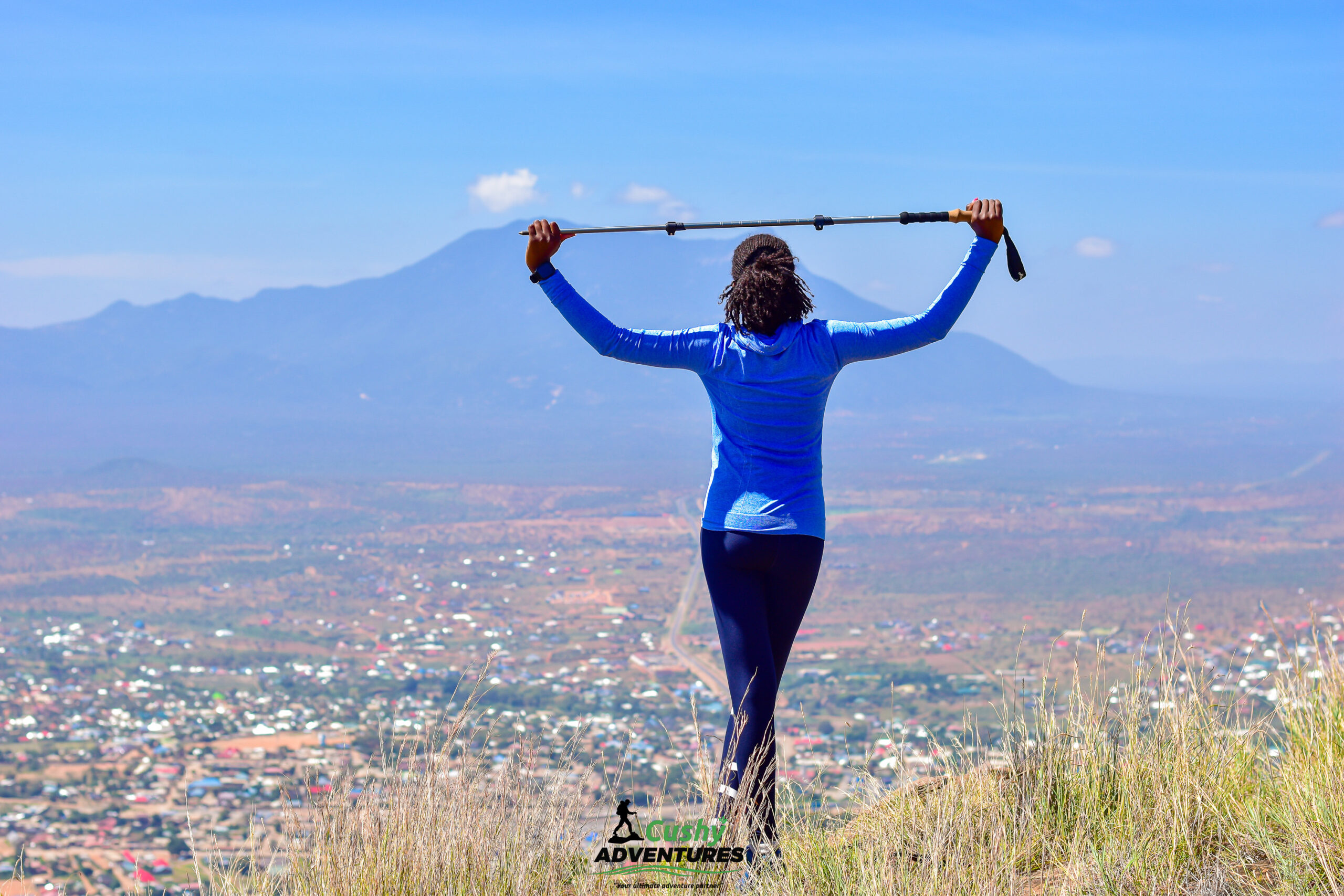 Lady admiring panoramic views of Namanga town, Mount Meru, and Longido from the Namanga Hills summit
