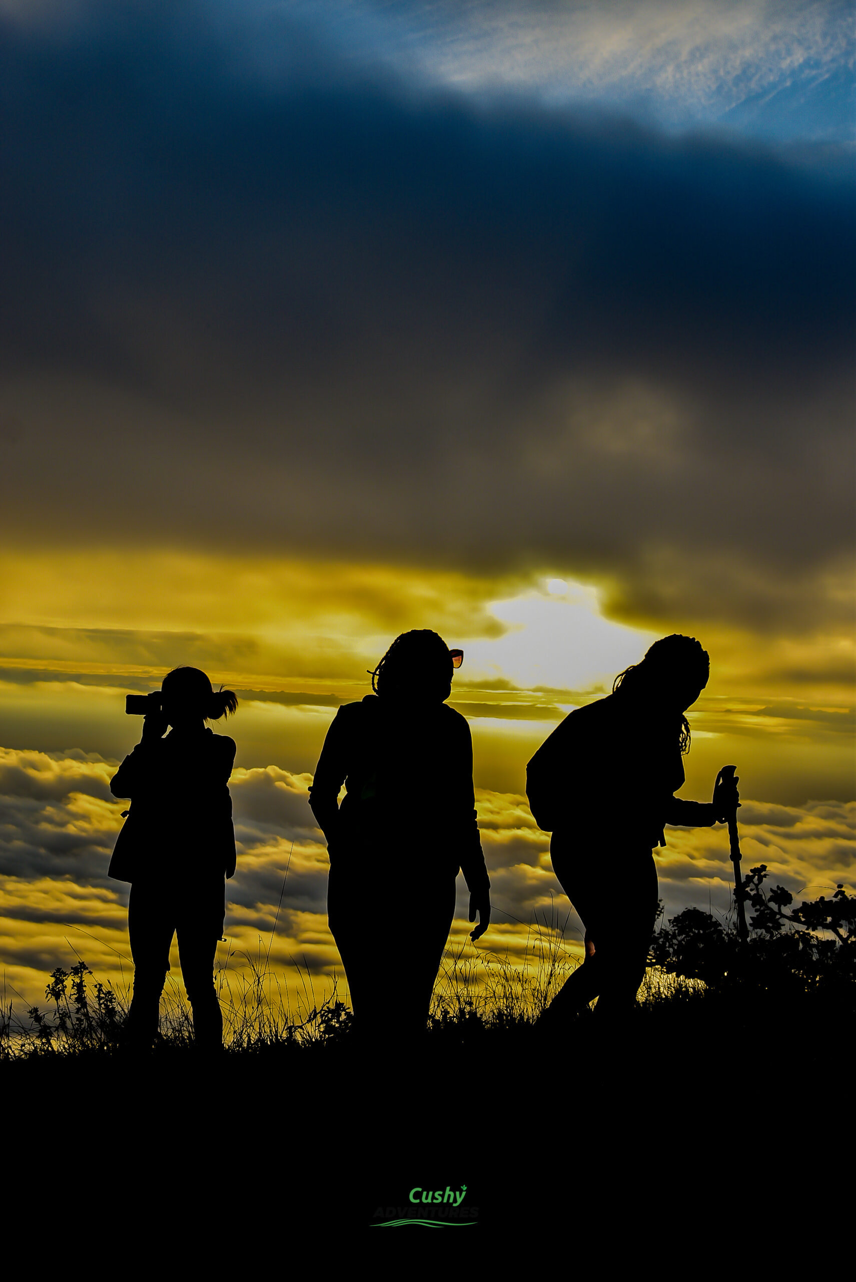 Three hikers silhouetted at sunrise