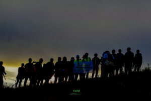 Group of hikers watching sunrise from mountain summit during Cushy Adventures hik